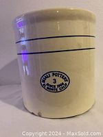 Front view showing double logos stamped on the side of the 3 gallon crock in blue ink along with the framed blue horizontal lines near top.