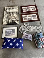 Overall view of the lot showing framed poster, photo collages, framed photo, wooden motorcycle sign, and pillows arranged on the floor