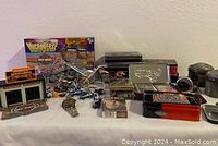 Overview of all items in the lot including Harley-Davidson Microverse box, tins, toy motorcycles, pistons, and other collectibles.