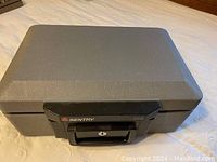 Gray Sentry 2110 fireproof safe with black handle and keyhole on front.