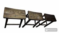 Group photo of three wooden stools stacked or aligned next to each other, showing seat surfaces and legs.
