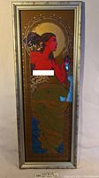 Full view of the framed Birth print showing the woman in red profile with gold foil sun background and silver frame