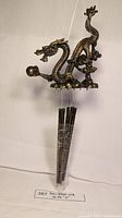 Photo of brass dragon wind chime showing detailed dragon figure and hanging tubes