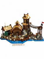 Full assembled LEGO Viking Village set with buildings, watchtower, rope bridge, rocky terrain, water elements, and 4 Viking mini figures.