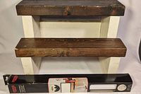 Photo of wooden step stool with dark brown steps and white side supports, shows surface and construction details.
