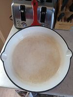Top view of 12 inch fry pan showing white enamel interior with light staining.