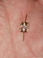 Close-up of the pair of 14k gold stud earrings with marquise cut blue topaz stones, shown held in hand to illustrate size and settings.