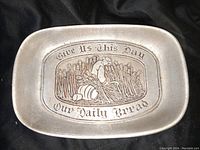 Top-down photo of the pewter dish showing detailed design and inscription.