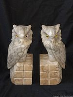 Pair of hand carved marble owl bookends front view against black background