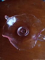 Top view of the pink glass strawberry pattern pick dish showing scalloped edges and central circular base.