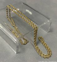 Full view of rope chain draped on clear stand