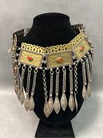 Front and angled view of the antique gilded silver Turkoman headband, showing detailed embossing and coral stones with hanging silver leaf-shaped charms.