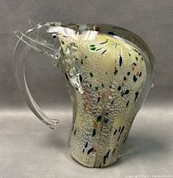 Front-side view of the clear art glass elephant figurine with colorful flecks and curved trunk revealing detailed features.