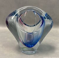 Front view of clear Bohemia art glass basket with blue interior accents and organic curved shapes.