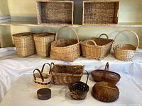 Wide view of the various woven baskets in different shapes and sizes displayed on surface.