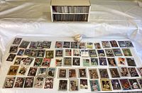 Wide view of numerous cards laid out in front of a two-shelf cardboard box