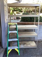 Full front view of metal storage shelf and Werner ladder showing condition and overall size