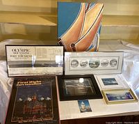 All items together on a flat surface, showing the full collection of framed maritime art and prints including posters and photos.