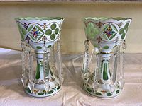 Front view of two matching luster vases side by side showing painted and cut-to-clear design with hanging prisms