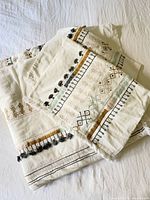 Folded set of duvet cover and two pillow shams showing embroidery details and pattern colors.