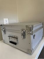 Closed view of silver metal camera case with latches and handle, showing exterior condition