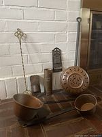 Photo showing complete lot: two copper pots with iron handles, brass fork, copper bed warmer, two copper wall mounts, and tall copper cylinder