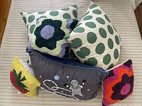 All six decorative pillows arranged together on a striped fabric surface.