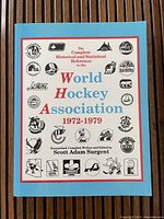Front cover of the WHA book showing title and logos of league teams.