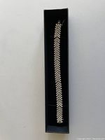 Full view of the silver rhinestone bracelet in a black box showing the chevron pattern design.