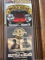 Stack of boxing programs showing 'Thomas vs Berbrick' and 'Holyfield vs Holmes' event covers.