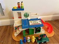Front and side view of the Sesame Street clubhouse playset with slide and figures on top and around it.