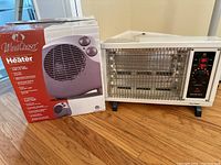 Photo of Wind Chaser box and Maxi-Heat space heater placed on a hardwood floor.