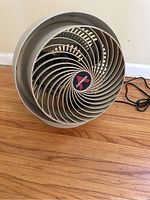 Front view of beige Vornado table top fan with circular grill and brand logo.