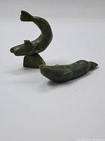 Photo showing jade seal carving and two green fish figurines, with one fish damaged