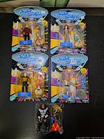 Five Star Trek The Next Generation action figures, four in original blister card packaging with accessories, one unboxed figure with accessories.