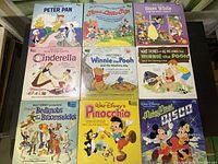Full view of nine vintage Disney LP record covers showing various movies and themes.