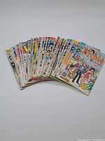 Photo showing a fanned stack of vintage Archie-related comic books on white background