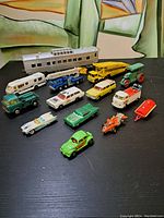 Full lot of assorted vintage toy cars and toy train rail car arranged on black surface