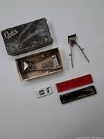 Photo of the manual hair clippers laid out with the original box and accessories showing all included items.