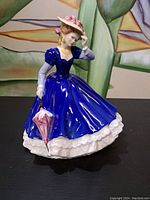 Front angle of the Royal Doulton Mary figurine showing detailed facial features, blue dress, and umbrella.