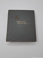 Front cover of Deluxe Stamp Stock Book album showing wear and a stain