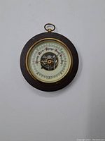 Full view of vintage round barometer with visible dial and wooden frame