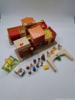 Full top-down view of all pieces including building, figures, swing set, vehicle, and small play accessories