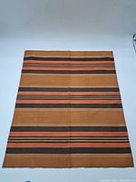 Full view of rectangular tapestry laid flat showing overall striped pattern and size