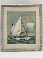Full view of framed watercolor painting of sailboat on the water with greenish white and tan sails