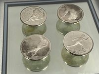 Four 1988 Olympic silver coins in mirror-backed frame with black border