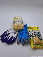 Lot of four pairs of gloves in purple, blue, gray colors and a wheel/spot detailing pad kit in packaging