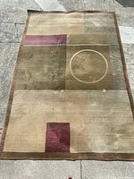 Top down view of the rectangular rug laid flat on concrete showing full design and colors in natural light.