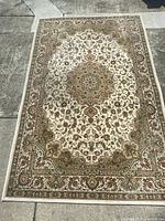 Full top view of the rug laid flat outdoors showing central medallion and border design