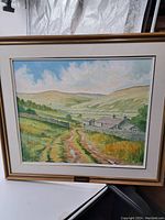 Framed oil painting showing a rural landscape with path, farmhouse, hills, and sky, signed by C. Wood.